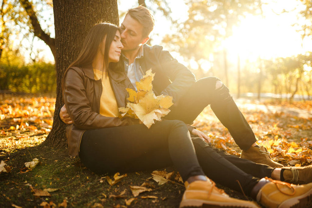 Lovely beautiful couple enjoying each other.  Beautiful autumn day. Lifestyle, happy couple of two play on a sunny day in the park. The concept of youth, love and lifestyle. - Foto, Imagen
