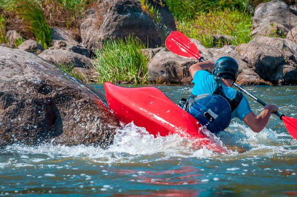 La navigation de plaisance. Un homme assis dans un kayak avec des rames à la main effectue des exercices sur l'eau. Kayak freestyle en eau vive. Rouleau esquimau
. - Photo, image