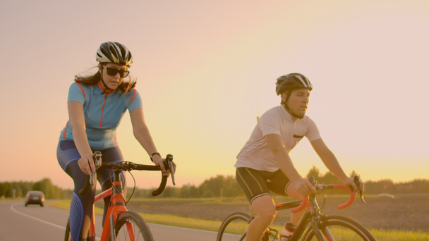 Lege ruimte. Sportieve vrienden op de fiets op de zonsondergang. Paar fietser gaan langs de kust. Sport in natuur achtergrond. Groep mensen twee Road Biker in Sunset - Video