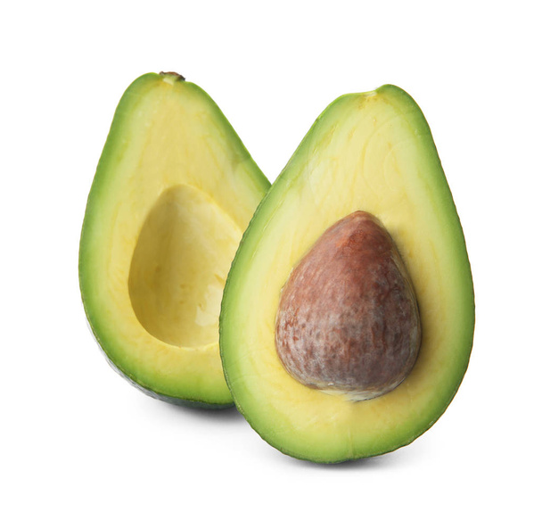 Halves of ripe avocado with pit on white background - Foto, Imagen