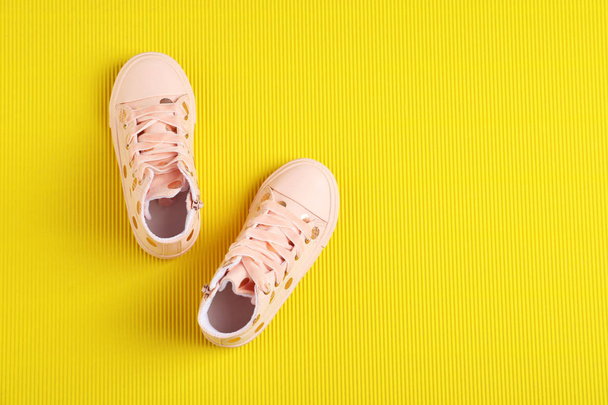 Pair of stylish child shoes on yellow background, flat lay. Space for text - Foto, imagen