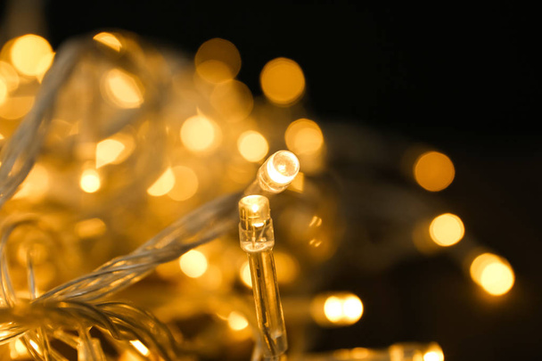 Glowing Christmas lights on table, closeup view - Valokuva, kuva