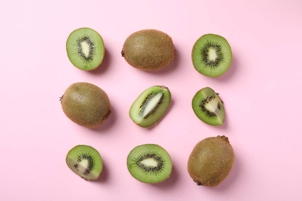 Top view of cut and whole fresh kiwis on pink background - Foto, Bild