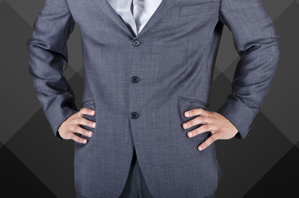 zakenman in pak, handen op de heupen - Foto, afbeelding