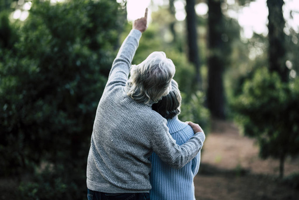 Couple of mature senior old people hug and enjoy outdoor leisure activity together  - Photo, Image