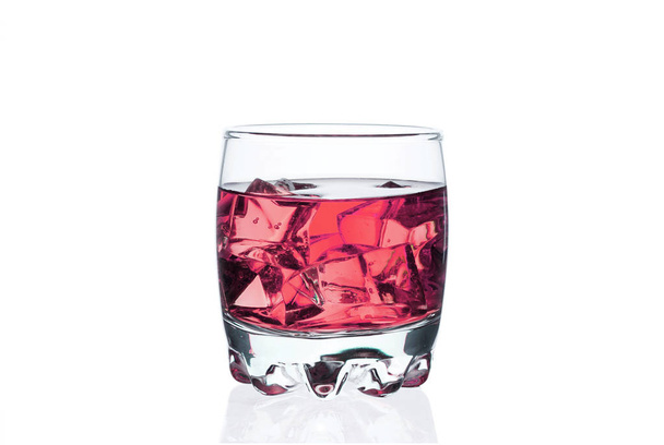 Pink drink with ice cubes in a glass on a white background. Chilled cocktail exotic. Tonic liquid directly from the bar. - Photo, Image