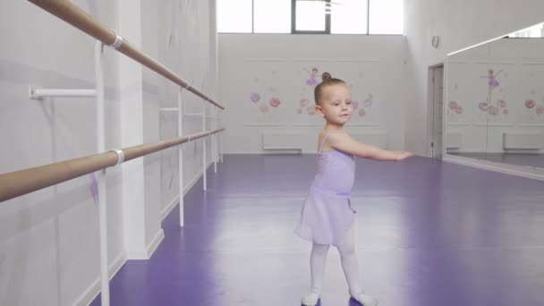 Χαριτωμένο μικρό μπαλαρίνα στο κορμάκι στροβιλίζεται στο χορό στη σχολή μπαλέτου - Πλάνα, βίντεο