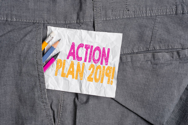 Πινακίδα κειμένου που δείχνει το σχέδιο δράσης 2019. Εννοιολογική στρατηγική προτεινόμενη φωτογραφία ή πορεία των ενεργειών για το τρέχον έτος εξοπλισμός γραφής και λευκό χαρτί σημείωμα μέσα τσέπη από το παντελόνι εργασίας του ανθρώπου. - Φωτογραφία, εικόνα