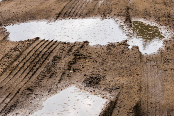 лужи в придорожной грязи телефото крупным планом с избирательным фокусом и размытием
 - Фото, изображение