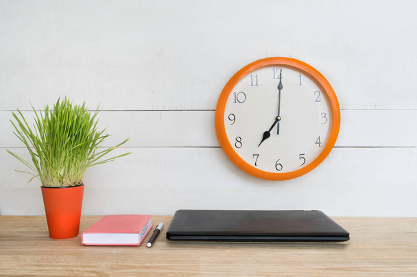 Wall clock, laptop, notebook and pen. Home workplace. Green houseplant on the table. White background. - Zdjęcie, obraz