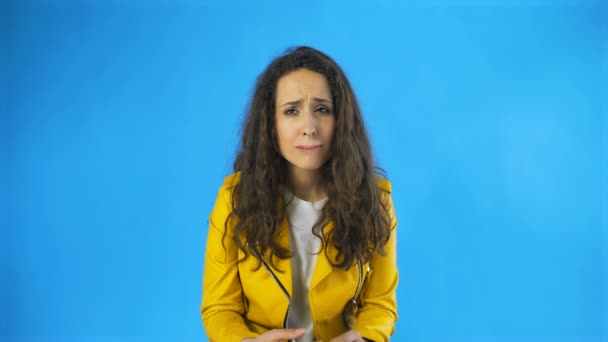 Csalódott és egy nagyon szomorú fiatal nő majdnem sír a stúdióban kék háttér. - Felvétel, videó