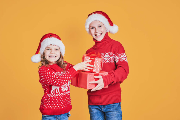 Happy children holding red gift boxes - 写真・画像