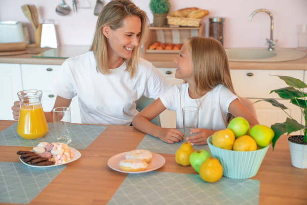 Healthy food at home. Happy family in the kitchen. Mother and child daughter are having breakfast. - Foto, Imagem