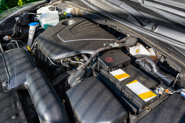 Nouveau compartiment moteur dans la voiture, parties visibles du moteur, câbles, lignes et réservoirs pour liquides
. - Photo, image