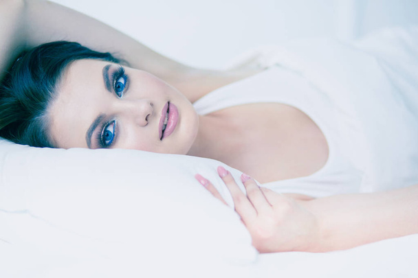 Young beautiful woman lying in bed. - Foto, imagen