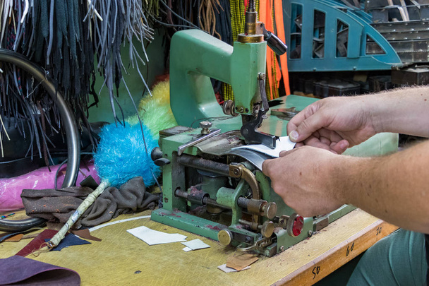 Mannelijke schoenmaker handen skiving leer met een vintage skiving machine. - Foto, afbeelding