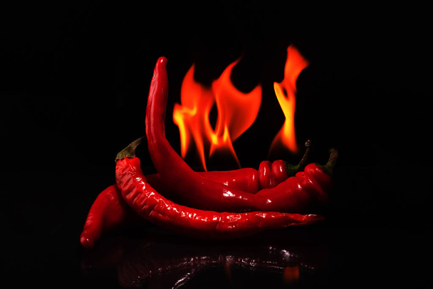 Red Hot Chili Spice "brandende pepers op een zwarte achtergrond" - Foto, afbeelding