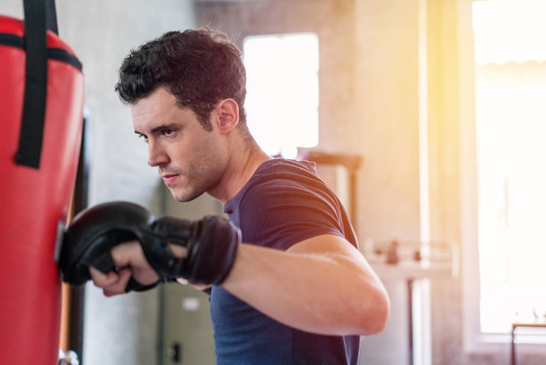 Hombre guapo en guantes de boxeo sacos de boxeo ejercicio en forma
  - Foto, Imagen