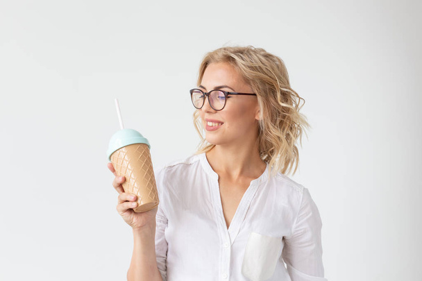 Retrato de mulher muito jovem está bebendo smoothie sobre fundo branco
 - Foto, Imagem