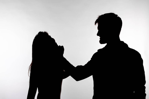 Aggression and abuse concept - man and woman expressing domestic violence in studio silhouette isolated on white background. - Photo, Image