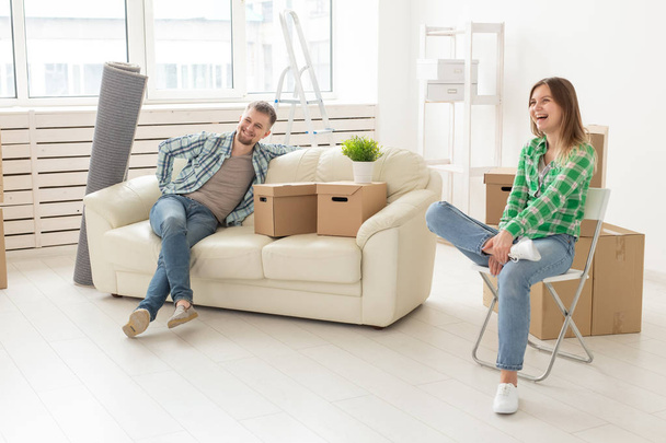 Positive smiling young girl sitting against her laughing in a new living room while moving to a new home. The concept of joy from the possibility of finding new housing. - 写真・画像