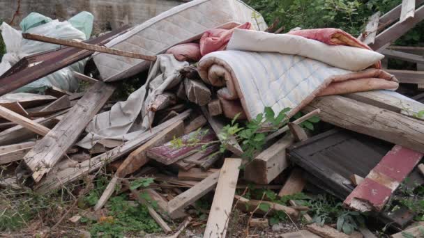 Dump. Vuilnis gedumpt in de werf in de buurt van het huis: planken, matras, Trooster - Video