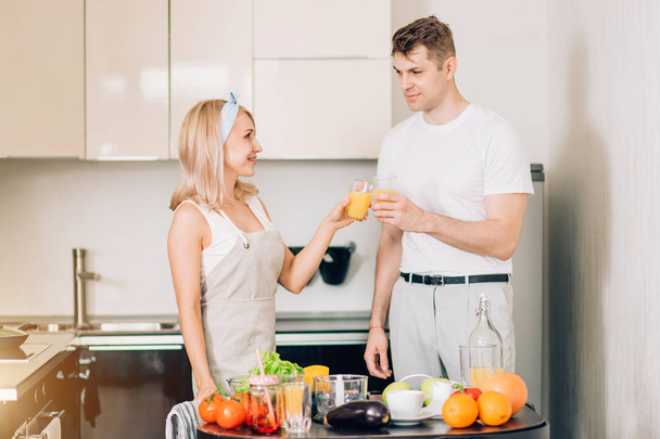 Couple making fresh organic juice in kitchen together - 写真・画像