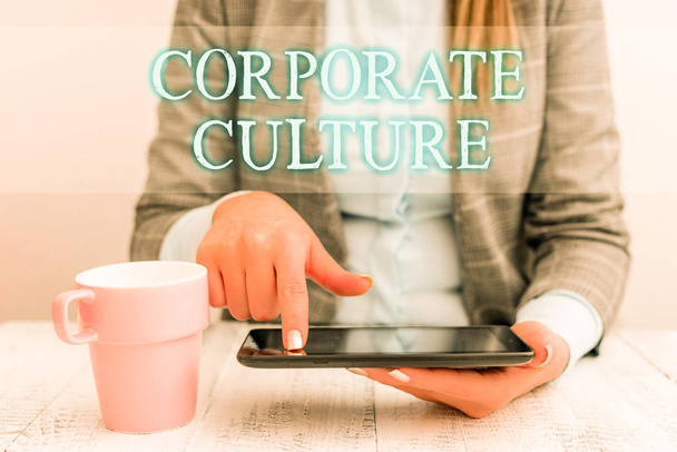 企業文化を書く手書きテキスト。携帯電話とコーヒーをテーブルの上に置いて座っている会社のビジネスウーマンを特徴づける広範な価値観と態度を意味する概念. - 写真・画像