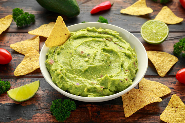 Bowl of fresh Guacamole with nachos chips and herbs. Healthy Vegan, Vegetables food. - Zdjęcie, obraz
