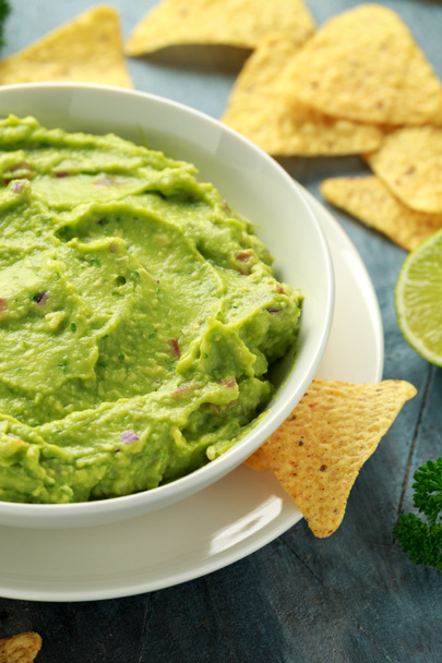 Bowl of fresh Guacamole with nachos chips and herbs. Healthy Vegan, Vegetables food. - Фото, зображення