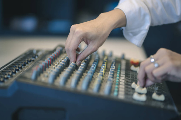 Tontechniker oder DJ stellt die Lautstärke des professionellen digitalen Audiokanal-Mischpults im Studio ein. - Foto, Bild