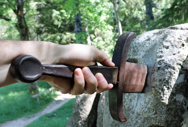 käsi ihmisen ja miekka kivessä
 - Valokuva, kuva