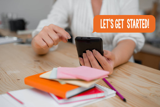 Текст для написания слов Let S Get Started. Бизнес-концепция для поощрения кого-то начать делать что-то женщина с помощью смартфона офис поставляет технологические устройства внутри дома
. - Фото, изображение