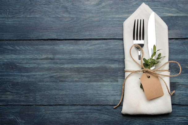 mise en table. couverts. Fourchette, couteau dans une serviette blanche sur une table en bois bleu. vue de dessus
 - Photo, image