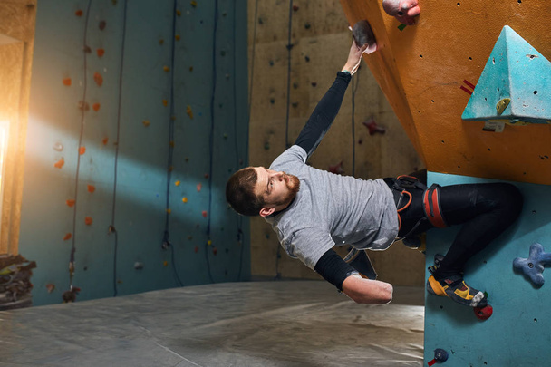 Powerful handsome boulderer without forearm training at climbing gym - Foto, Bild
