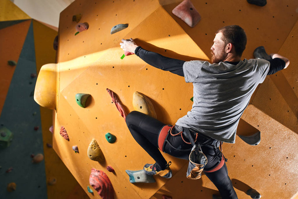 Motivated muscular boulderer with physical disability climbing up high - Fotó, kép