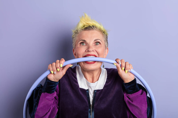 crazy mad old woman with hoop in her mouth, biting hoop with teeth - Фото, зображення