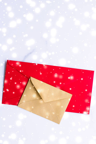 Winter vakantie blanco papieren enveloppen op marmer met glanzende sneeuw f - Foto, afbeelding