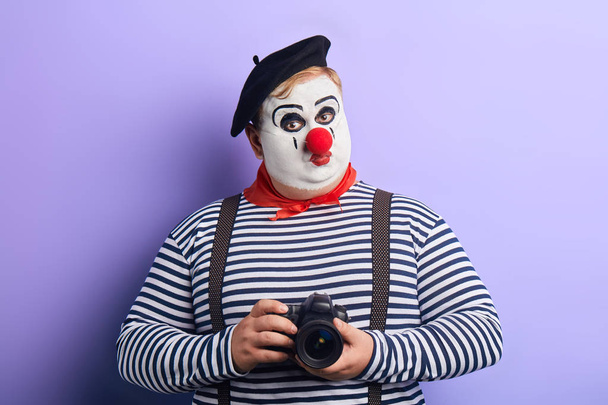 funny serious mime taking photo with film camera isolated on blue - Foto, Imagem
