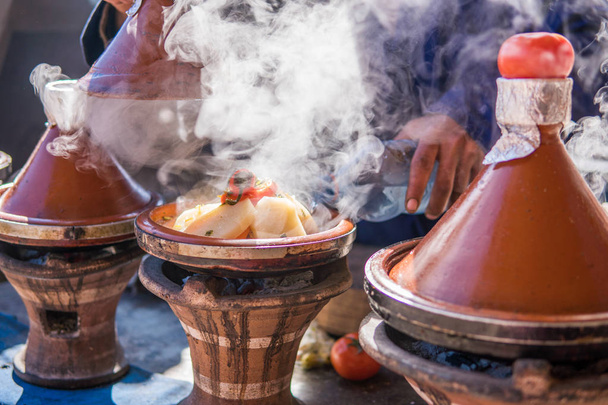 Morroco sokakta şehir meydanında bir açık barbekü buhar buharı geleneksel Tajine pişirme adam bir el - Fotoğraf, Görsel