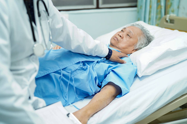 Infirmière physiothérapeute asiatique médecin touchant une patiente âgée ou âgée asiatique avec amour, soins, aide, encouragement et empathie à l'hôpital infirmier : concept médical solide et sain
. - Photo, image