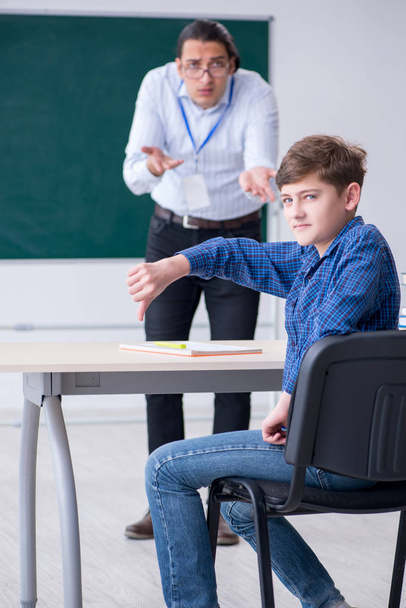 Νεαρός δάσκαλος και αγόρι στην τάξη  - Φωτογραφία, εικόνα