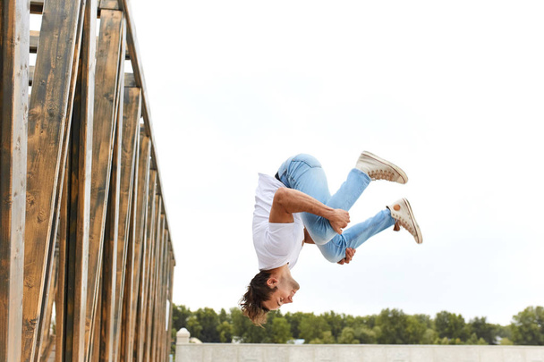 young man in comfortable stylish casual clothes doing crazy stunts - Photo, Image