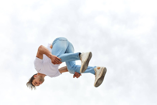 Fitness guy doing parkour trick while jumping in the air - Foto, Imagem