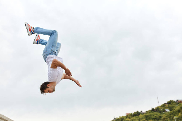 stuntman performing backward somersault, full length photo - 写真・画像
