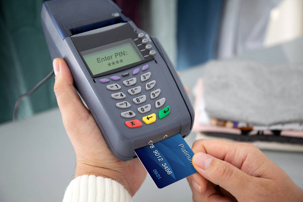 Man hand holding plastic card and pay pass online terminal  - Fotó, kép