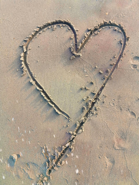 Σχεδιάζοντας το σύμβολο της καρδιάς στην άμμο - Φωτογραφία, εικόνα