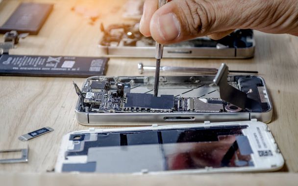 Iphone motherboard repairs into the motherboard for smartphone By professional technician on desk - Foto, Imagen