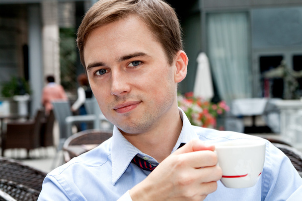 portrét smějící se mladý podnikatel se šálkem kávy - Fotografie, Obrázek