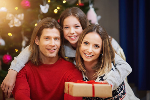 Όμορφη οικογένεια με δώρα πάνω από το χριστουγεννιάτικο δέντρο - Φωτογραφία, εικόνα